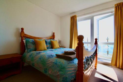 a bedroom with a bed and a large window at Seaview Beach house stones throws from the sea in Seaford