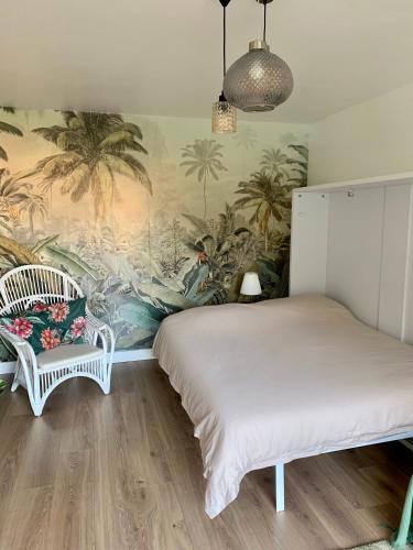 - une chambre avec un lit et un mur orné de palmiers dans l'établissement My Little Provence HYERES, à Hyères