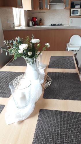 a table with a white vase with flowers in it at Prázdninový dům Bezkov u Znojma in Bezkov