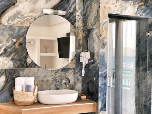 a bathroom with a sink and a mirror at Anagennisi Hotel in Skala