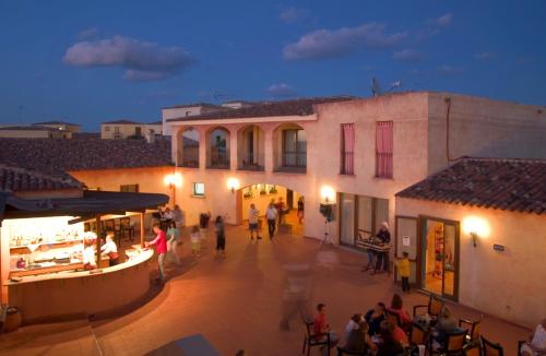 a group of people walking in a courtyard of a building at Club Esse Gallura in Aglientu