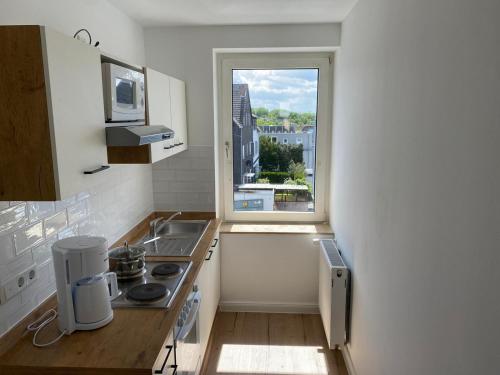 a kitchen with a sink and a window at interaktiv Appartements in Heiligenhaus - Hauptstrasse in Heiligenhaus