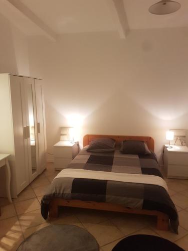una camera da letto con un grande letto con due comodini di Maison à la semaine a Vitrolles