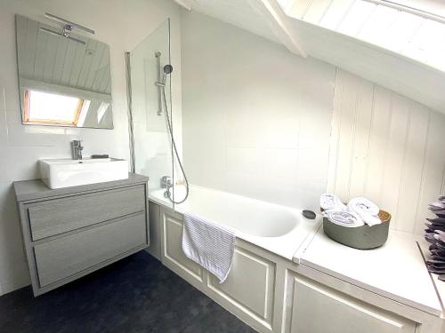 een witte badkamer met een wastafel en een spiegel bij Duplex LE GLENCOE in Honfleur