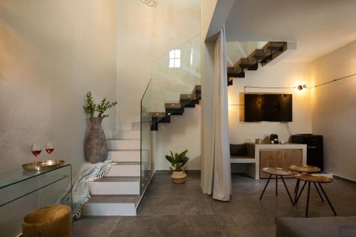 a living room with a staircase with a tv at Lindos Serenity Suites in Líndos