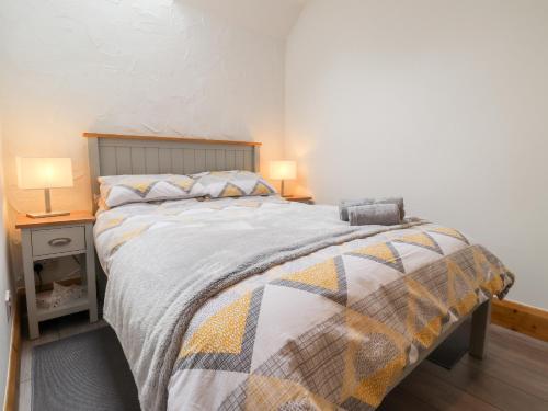 a bedroom with a large bed with two lamps at 3 The Barn in Haverfordwest