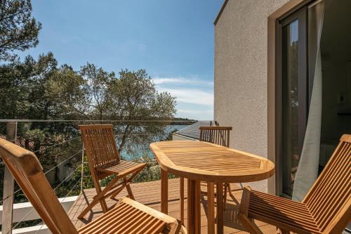 a wooden table and chairs on a balcony at Villa del Mar in Mali Lošinj