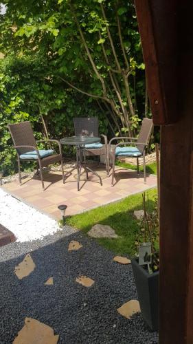 three chairs and a table in a garden at Joy Guesthouse in Siófok