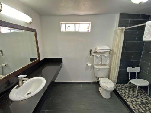 a bathroom with a sink and a toilet and a mirror at Rodeway Inn Ventura in Ventura