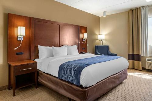 una habitación de hotel con una cama grande y una silla en Comfort Inn Warren, en Warren