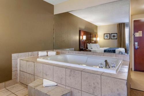 a large bath tub in a hotel room with a bed at Comfort Inn Warren in Warren
