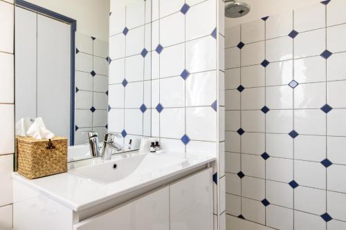 a bathroom with a sink and blue and white tiles at Le Homard Bleu in Saint-Trojan-les-Bains