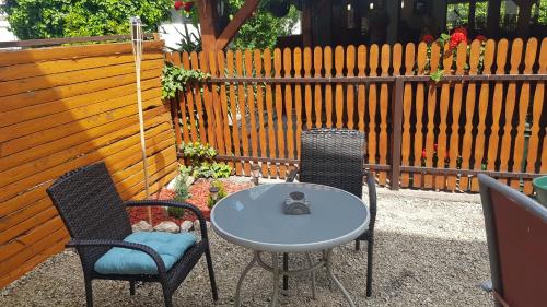 a table and two chairs and a table and a fence at Joy Guesthouse in Siófok