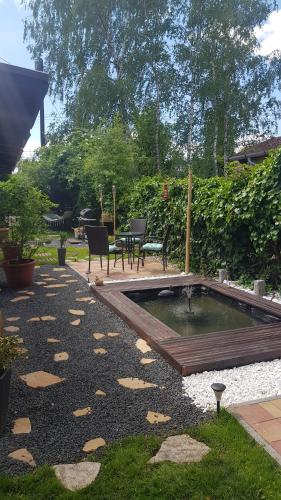 a garden with a pond and a table and chairs at Joy Guesthouse in Siófok