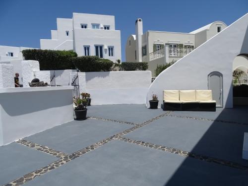 a patio with a couch in front of white buildings at NEOKLASSIKO KOUKOULI in Fira