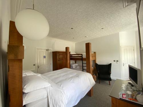 a bedroom with a white bed and a desk with a television at Rooms36 in Keswick
