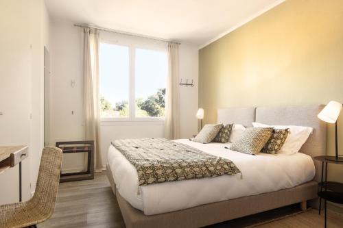 a bedroom with a large bed and a window at Le Homard Bleu in Saint-Trojan-les-Bains