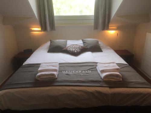 a bedroom with a bed with towels on it at Hotel Heijenrath in Heijenrath