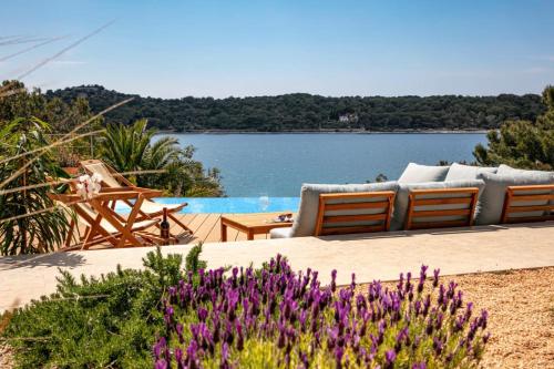 a patio with a view of the water and flowers at Villa del Mar in Mali Lošinj