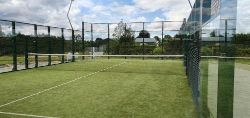 a tennis court with a net on a tennis court at Bungalows at Sierra Golf Resort in Wejherowo