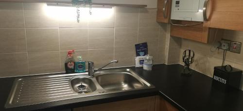 a sink in a kitchen with a black counter top at 18 Sea View Close in Scarborough