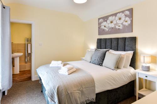 a bedroom with a large bed and a bathroom at Guest Homes - Gerald House in Swansea