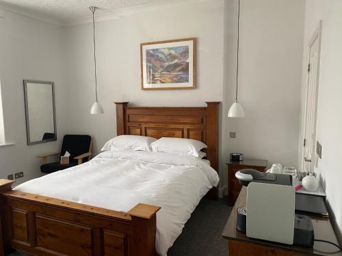 a bedroom with a bed and a desk with a chair at Rooms36 in Keswick