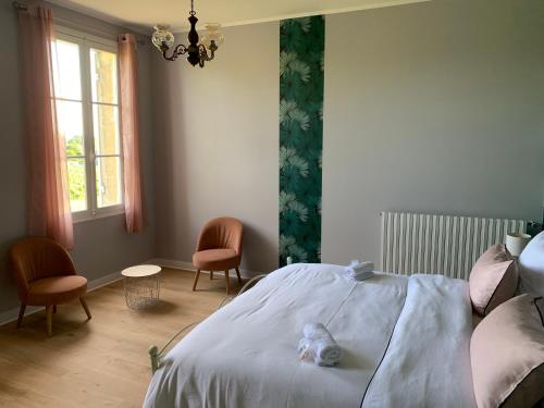 a bedroom with a bed with a stuffed animal on it at Château Roseyrol proche Saint-Emilion in Saint-Magne-de-Castillon