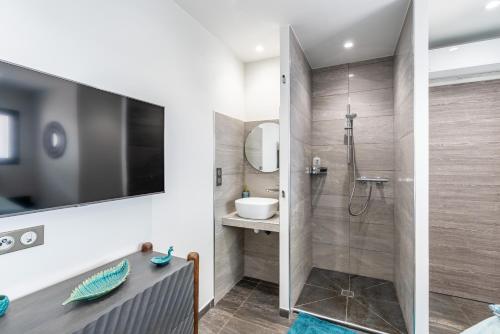 une salle de bain avec une douche à l'italienne et un lavabo dans l'établissement Les Jardins de la Palmeraie - Sublime vue sur la baie dAjaccio, à Porticcio
