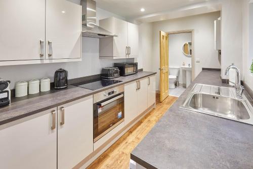 - une cuisine avec des placards blancs et un évier dans l'établissement Host & Stay - Clifton House, à Scarborough