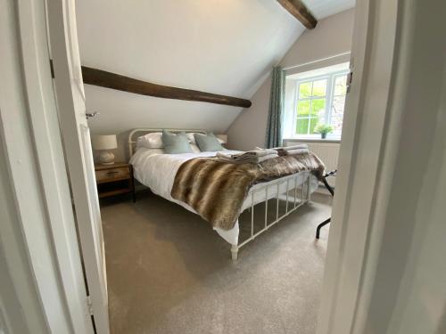 Tempat tidur dalam kamar di Stable Lodge at Bledington Mill