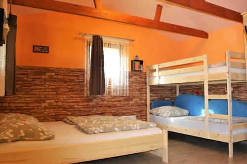a bedroom with two bunk beds and a brick wall at Eszter Nyaralóház in Zánka