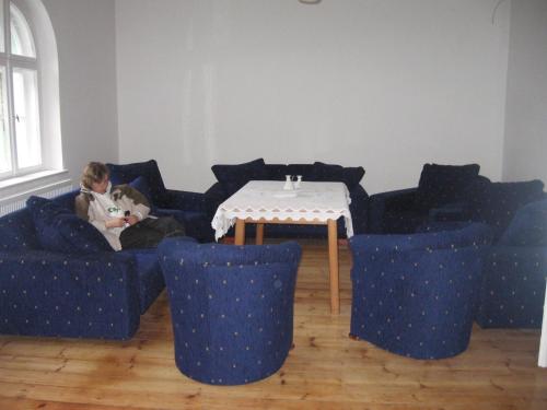 a boy sitting on a couch with a teddy bear at Baltic Home in Polanica-Zdrój