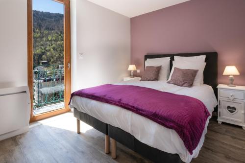 une chambre avec un grand lit et une grande fenêtre dans l'établissement LES CHARMETTES, à Brides-les-Bains