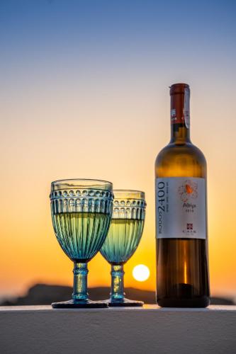 a bottle of wine next to two wine glasses at THE SHIP in Lefkos Karpathou