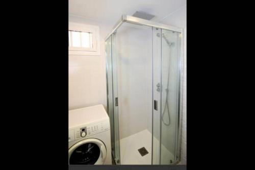 y baño con cabina de ducha y lavadora. en Dori Seaview Apartment, en Benidorm