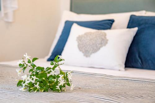 a bed with blue and white pillows and a plant at THE SHIP in Lefkos Karpathou