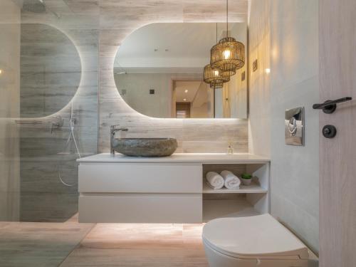 a bathroom with a sink and a mirror and a toilet at Villa Verde - Heated Pool with Stunning Views, by ZanteWize in Kallithea