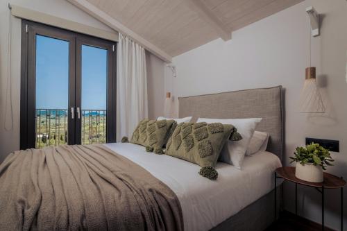 a bedroom with a bed with a large window at Villa Verde in Kallithea