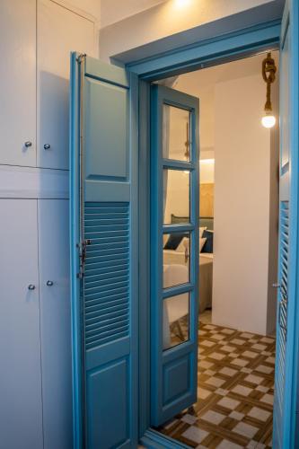 a blue door in a room with a mirror at THE SHIP in Lefkos Karpathou
