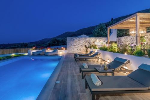 an infinity pool with lounge chairs and a villa at Villa Verde - Heated Pool with Stunning Views, by ZanteWize in Kallithea