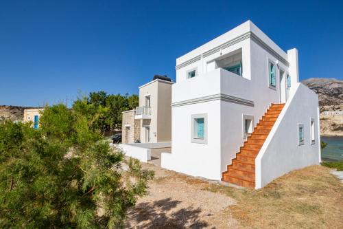 a white house on the side of a hill at THE SHIP in Lefkos Karpathou