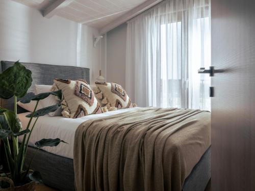 a bedroom with a bed with pillows and a window at Villa Verde - Heated Pool with Stunning Views, by ZanteWize in Kallithea