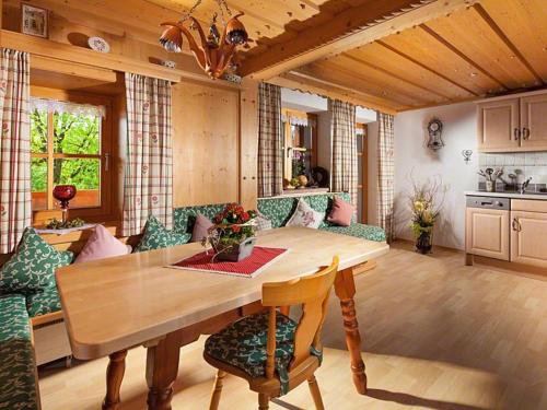 uma sala de estar com uma mesa de madeira e cadeiras em Hinterkeilhof em Bischofswiesen