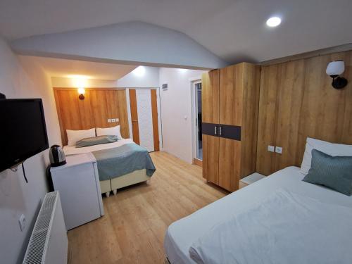 a bedroom with two beds and a flat screen tv at Kuloğlu Otel ve Restoran in Uzungol