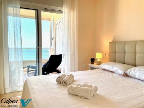 um quarto com uma cama branca e toalhas em Playa de Oro 17C Peñon & Sea View Arenal Beach em Calpe
