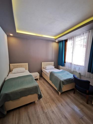 a bedroom with two beds and a window at Kuloğlu Otel ve Restoran in Uzungol
