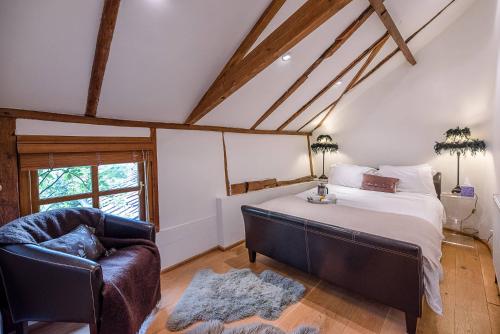 a bedroom with a bed and a chair and a window at The Hayloft Clopton Air Manage Suffolk 