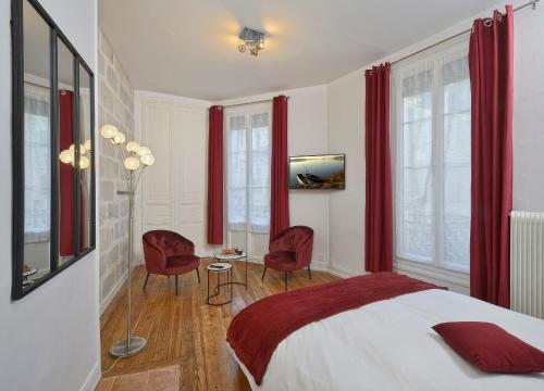 a bedroom with red curtains and a bed and chairs at Hypercentre 9 rue de la ROE in Angers