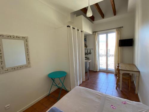 - une chambre avec un lit, un miroir et une table dans l'établissement Studios Floreal, à Nice